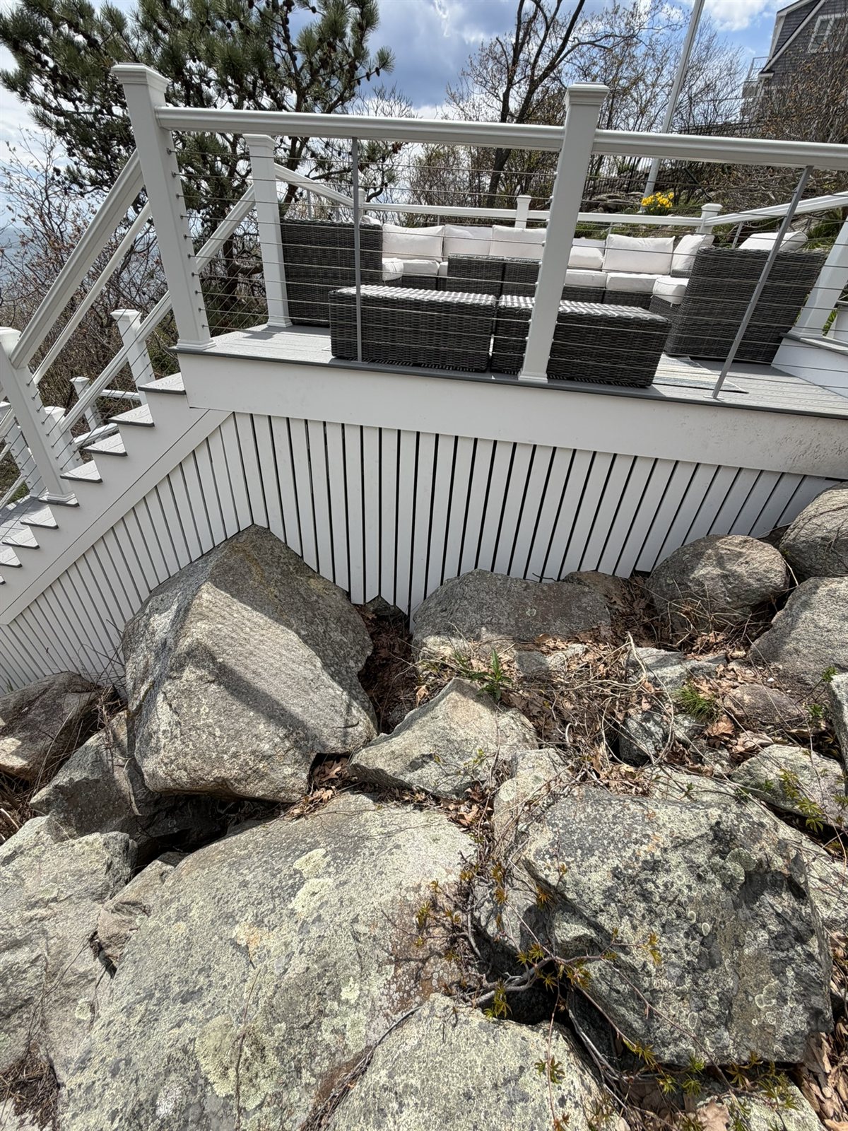 Custom white vertical-slat skirting installed around the deck base, sealing it against wildlife access.